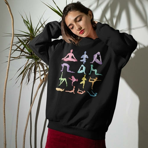 Woman wearing Yoga Theme Crewneck Sweatshirt with pastel yoga pose graphics on relaxed black loose fit fabric