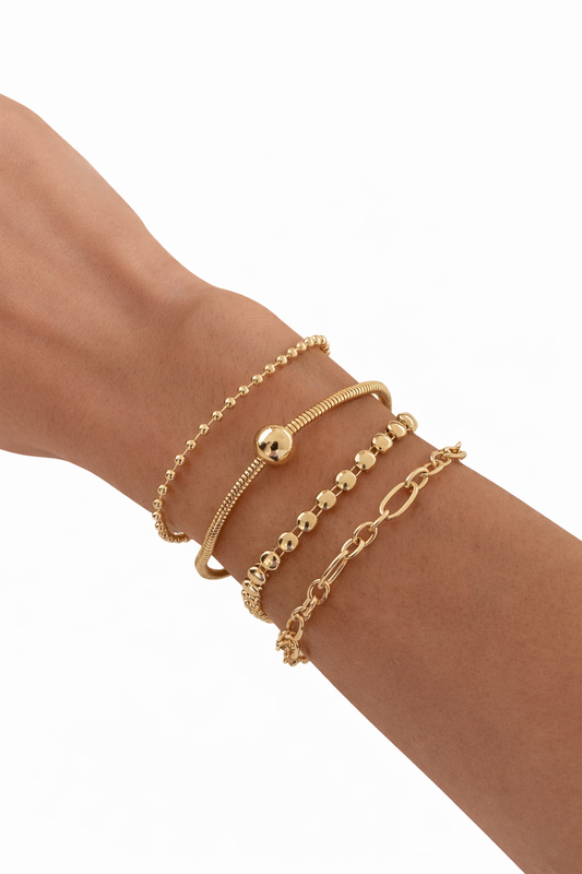 Close-up of a wrist adorned with Sport Layered Bracelet Set Adjustable Four Piece Stackable Casual in gold tones