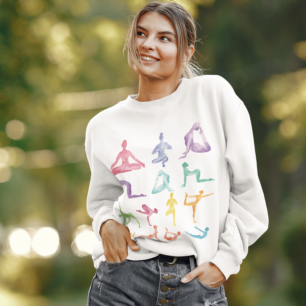 Woman wearing Yoga Theme Crewneck Sweatshirt featuring colorful yoga pose silhouette design outdoors