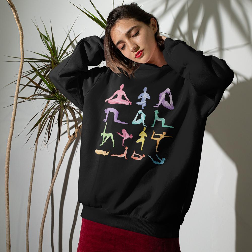 Woman wearing Yoga Theme Crewneck Sweatshirt with pastel yoga poses printed on black relaxed fit fabric